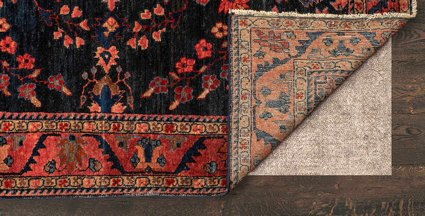 Rug with corner folded back to reveal rug pad underneath.