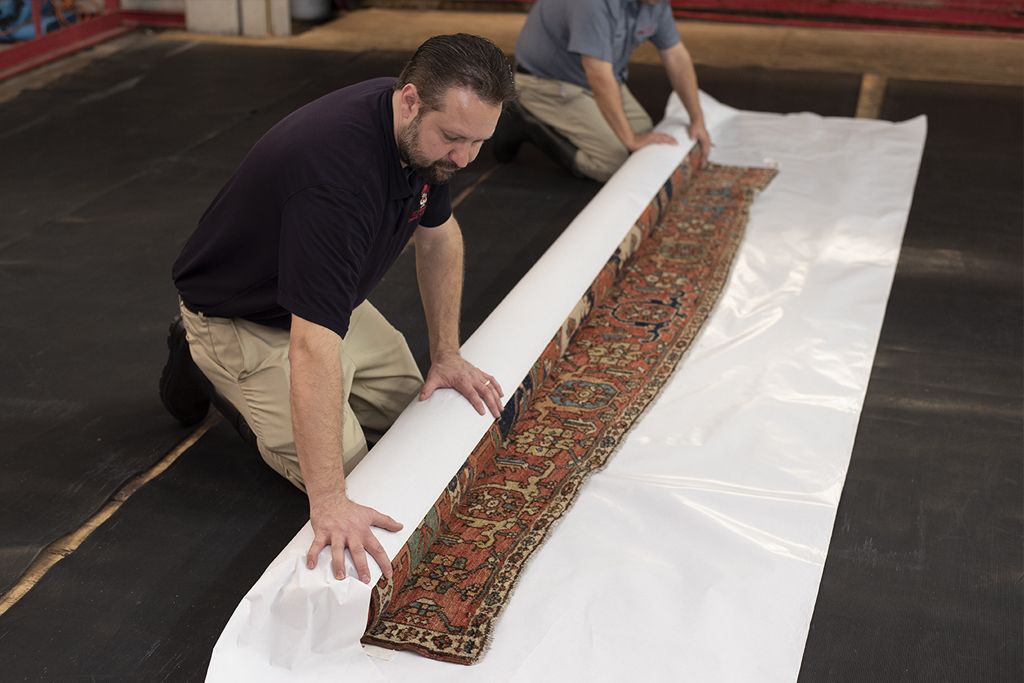 The Aladdin team wraps and protects an antique oriental rug for long-term storage to prevent damage and bug infestation