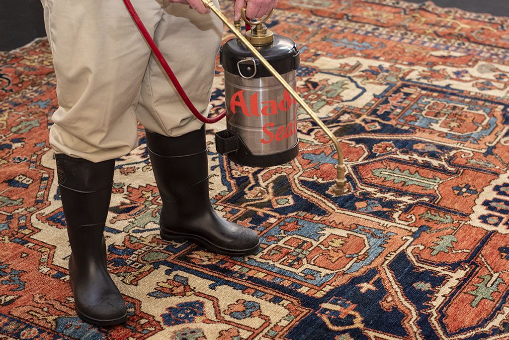 An Aladdin cleaning specialist applies industry-leading fabric protection to an oriental rug