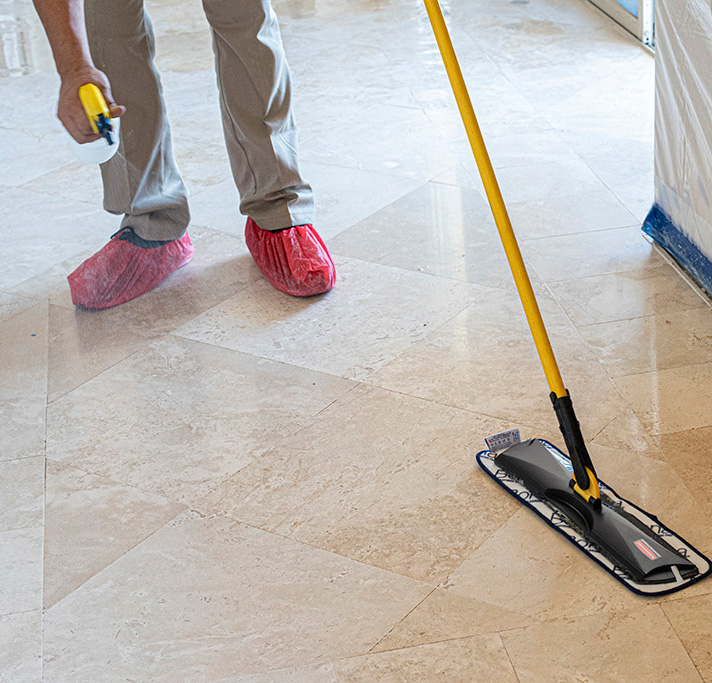 A cleaning specialist applies professional-grade sealer to professionally cleaned stone floor to provide a protective barrier