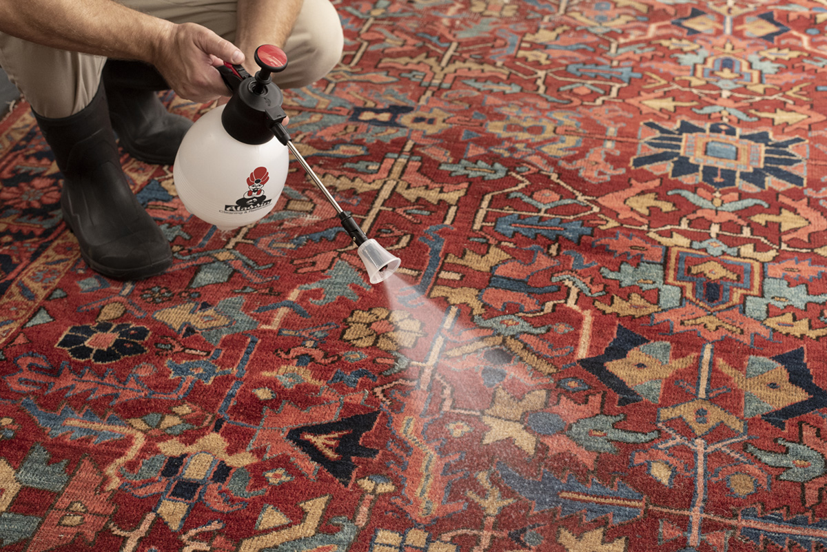 Fabric protection is applied to clean and dry oriental rugs to prevent spots and stains