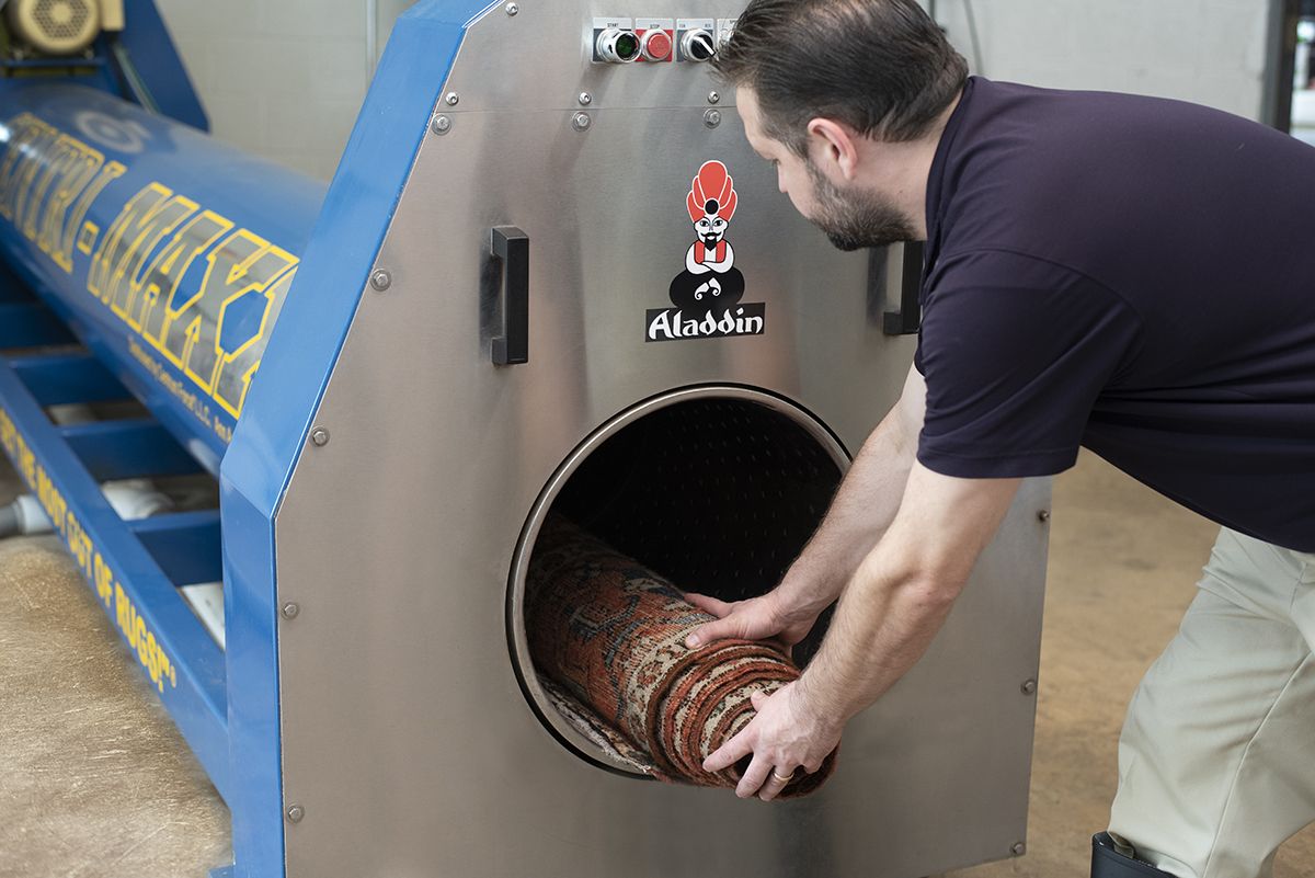 Cleaned oriental rug is placed into large rug centrifuge to remove excess water and begin drying process