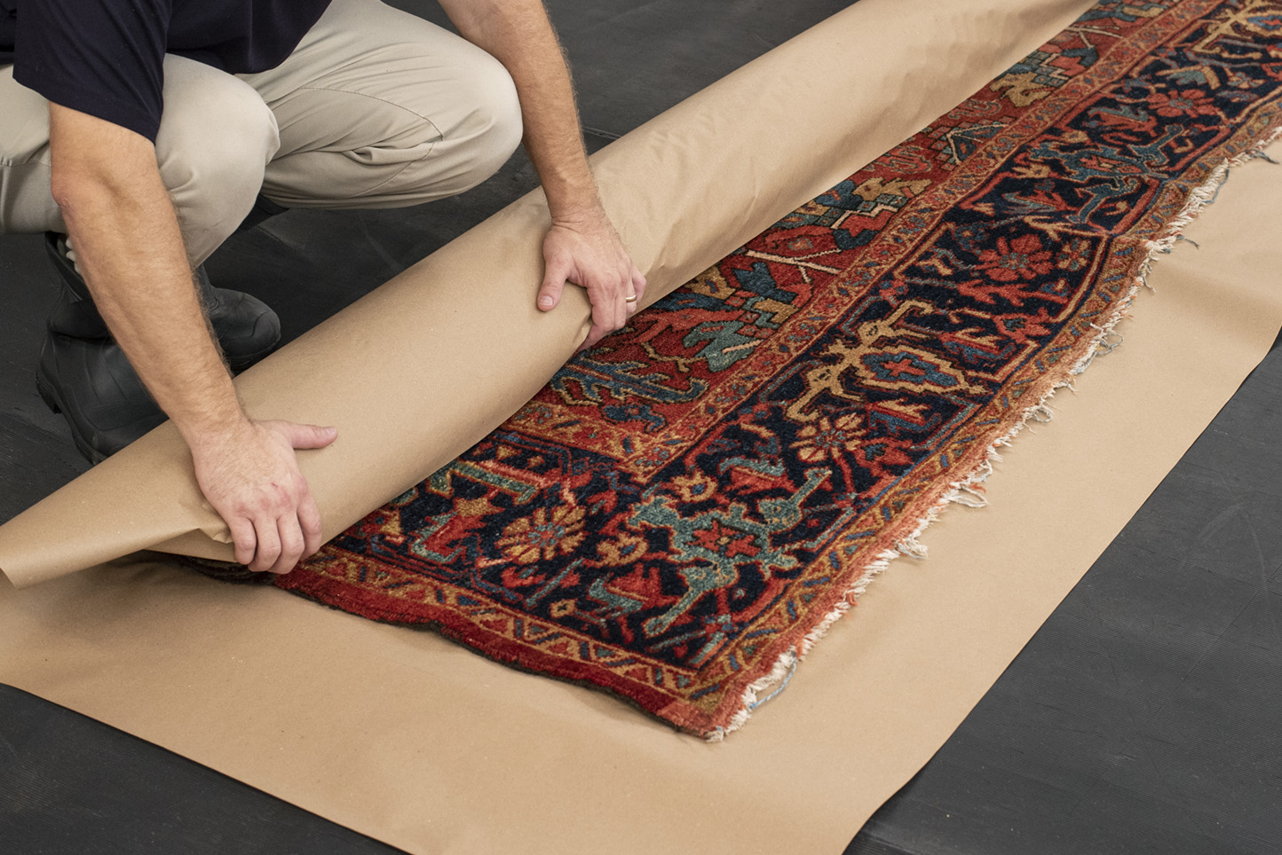 An oriental rug is properly rolled and wrapped for shipping or storage