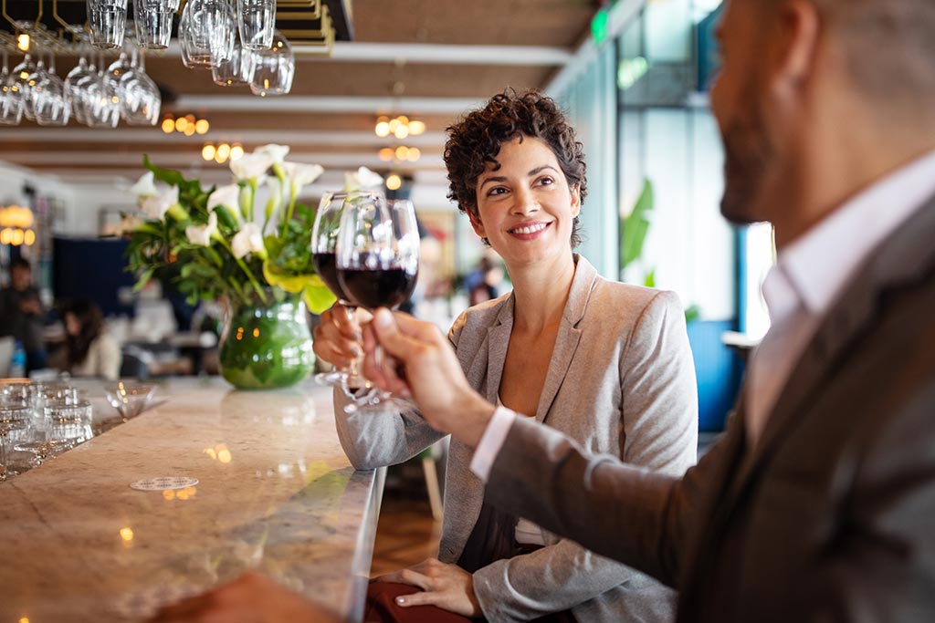 people sitting at marble bar drinking wine