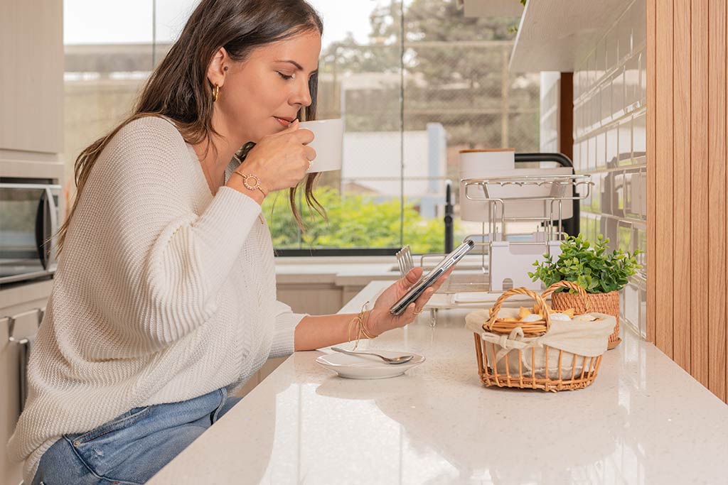 woman drinking at marble kitchen counter
