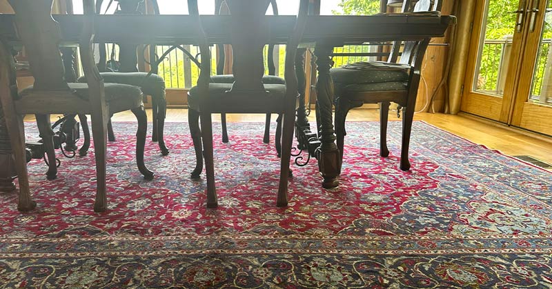 An oriental rug placed under a dining room table