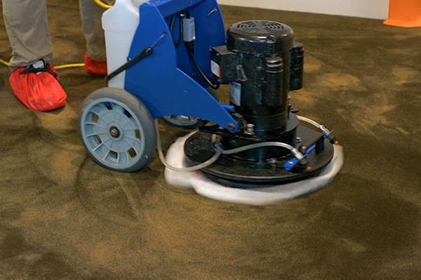 A close up photo of an Aladdin Cleaning technician performing encapsulation carpet cleaning in San Antonio home
