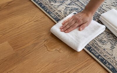 Clean white towels beside a small fresh spill on the edge of a patterned area rug.